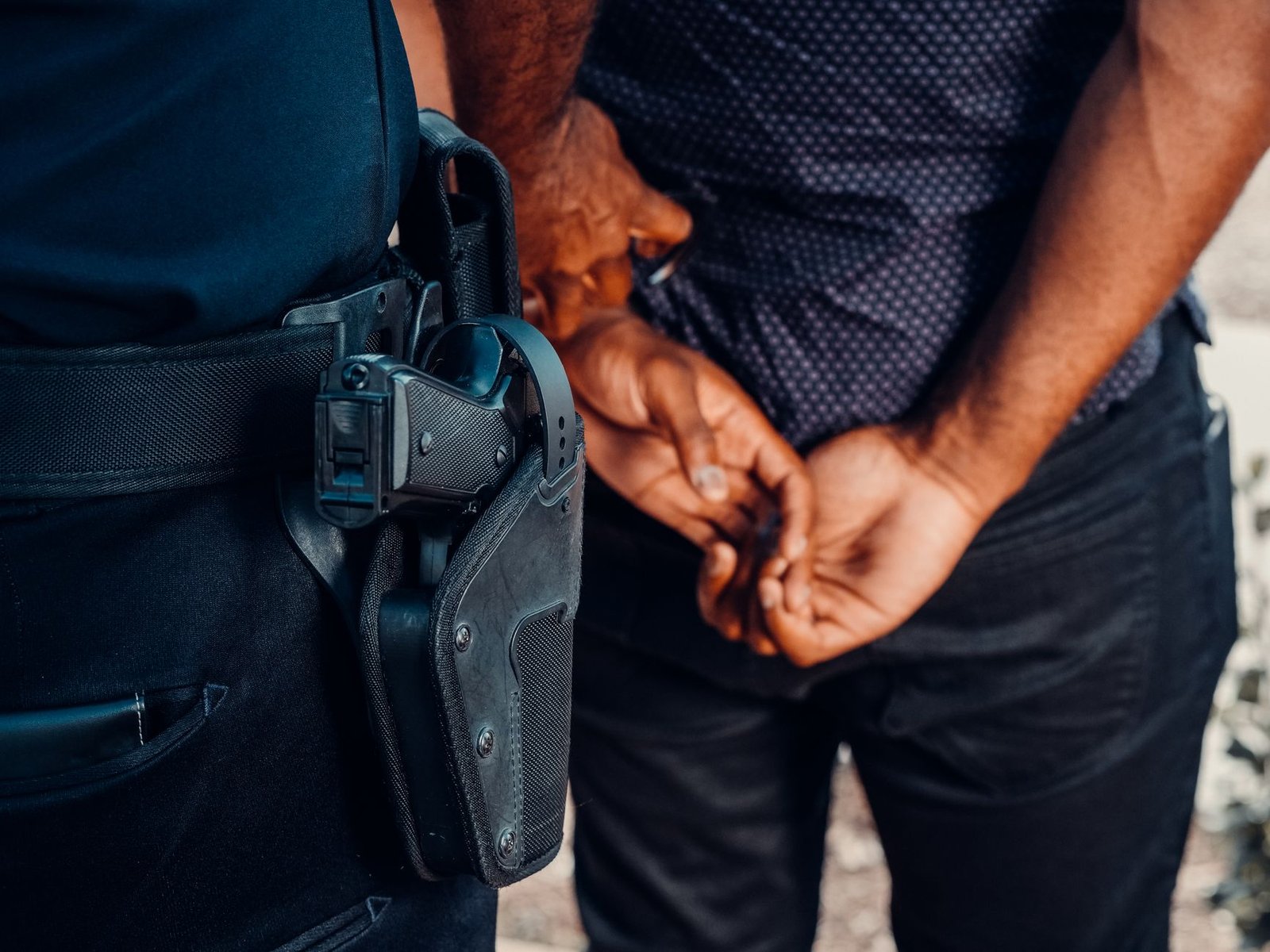 man in black leather jacket holding black leather bag
